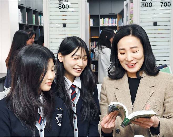 지난달 17일 인천 미추홀구 인주중학교 도서관에서 장현아(오른쪽) 사서 교사가 학생들과 책을 보고 있다. /고운호 기자
