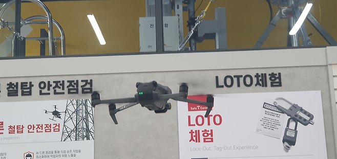 작업대 앞에 마련된 1m 사이즈의 드론이 붕 떠올라 철탑 주변을 날고 있다.ⓒ데일리안 조인영 기자