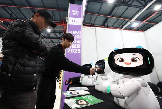 서울 강남구 세텍에서 열린 서울시 시니어 일자리박람회를 찾은 방문객이 돌봄로봇 다솜K와 대화하고 있다. [뉴스1]