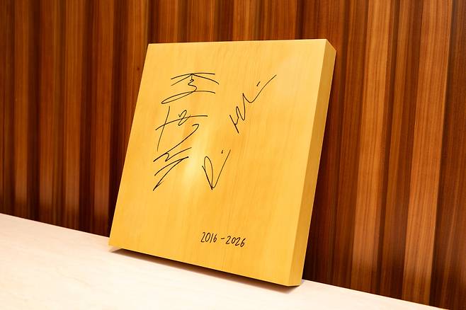 이재명 대통령에게 데미스 허사비스 구글 딥마인드 최고경영자(CEO)가 27일 선물한 바둑판. 2016년 알파고 대국 10주년을 기념해 이세돌 9단과 허사비스 CEO가 서명한 바둑판이다. [연합]