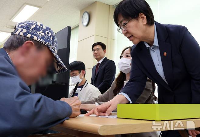 [세종=뉴시스] 강종민 기자 = 정부의 고유가 피해지원금 1차 신청·지급이 시작된 27일 정은경 보건복지부 장관이 세종시 조치원읍 북세종통합행정복지센터를 찾아 한 주민의 신청을 돕고 있다. 2026.04.27. ppkjm@newsis.com