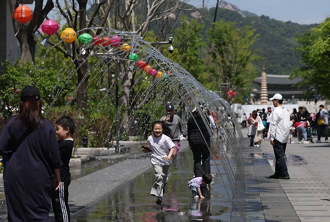 낮 최고기온이 25도 안팎의 초여름 날씨를 보인 26일 서울 광화문광장에서 어린이가 분수터널을 지나며 즐거워하고 있다. 연합뉴스