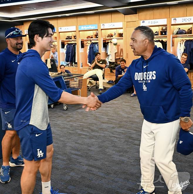 미국프로야구 메이저리그(MLB) LA 다저스의 김혜성이 28일(한국시간) 구단 라커룸에서 2025시즌 월드시리즈 우승 반지를 전달받은 뒤 데이브 로버츠 감독과 악수하고 있다. (LA 다저스 구단 공식 인스타그램 캡처) 2026.4.28 ⓒ 뉴스1 김진환 기자