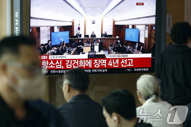 28일 오후 서울시 용산구 한강대로 서울역 대합실에서 시민들이 자본시장과 금융투자업에 관한 법률 위반, 정치자금법 위반, 특정범죄 가중처벌 등에 관한 법률 위반(알선수재) 혐의를 받는 김건희 여사의 항소심 선고공판 생중계를 지켜보고 있다.  2026.4.28 ⓒ 뉴스1 박정호 기자