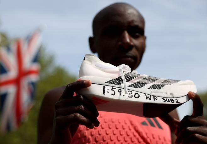 케냐의 사바스티안 사웨가 2026년 4월 26일 영국 런던에서 열린 런던 마라톤 엘리트 남자부 경기를 마친 후 러닝화를 들어보이고 있다. AP/뉴시스