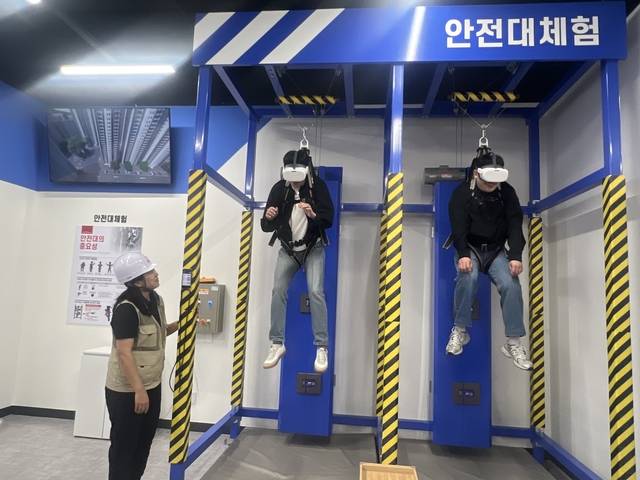 기자들이 지난 24일 대전 중구 SK텔레콤 안전체험교육관 ‘세이프 T 센터’에서 27층 아파트 옥상 안테나 보수 작업을 체험하고 있다. 이혜선 기자