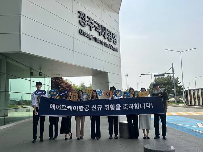 에어로케이항공 임직원들이 지난 27일 청주∼이창 신규 취항을 기념하는 축하 현수막을 들고 있다. 에어로케이항공 제공