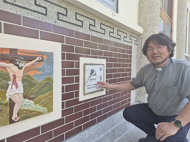 이동훈 주임신부가 ‘골고타 아리랑 십자가의 길’에 대해 설명하고 있다. 예수가 돌아가시는 장면이 ‘죽을 사’ 한자와 함께 노랫말로 표현되어 있다. 이주현 기자