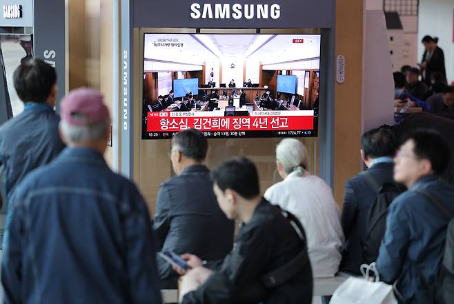 28일 서울역 대합실에서 시민들이 통일교 금품 수수와 도이치모터스 주가조작, 명태균 무상 여론조사 등의 혐의를 받는 김건희 여사 항소심 선고공판 생중계를 시청하고 있다.  이날 항소심 재판부는 김건희 여사에게 징역 4년, 벌금 5000만원 등을 선고했다. 연합뉴스