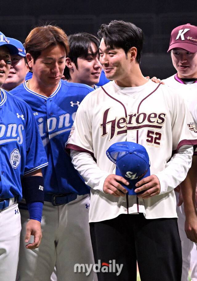 강민호가 박병호가 들고 있는 모자의 위치를 바라보고 있다.