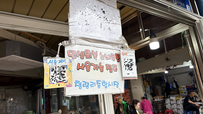 청량리 청과물시장 한 상점에 지난해 지급된 ‘민생회복 소비쿠폰’ 사용 가능 점포 안내문이 붙어있다. 박연수 기자