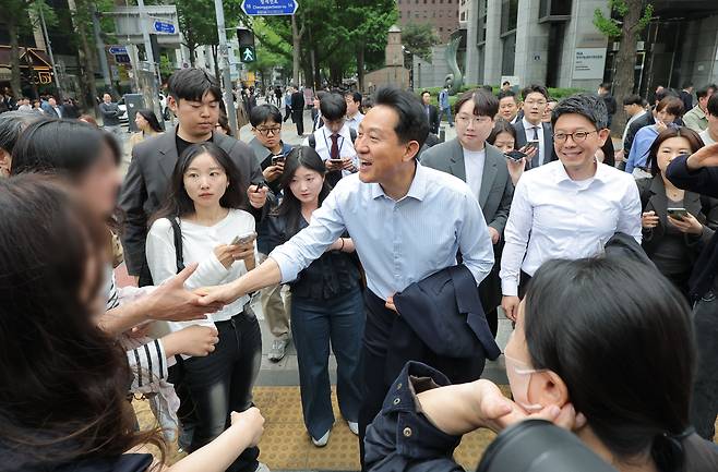 오세훈 국민의힘 서울시장 후보가 27일 기자회견을 위해 서울시청을 나와 보신각으로 향하며 시민들에게 인사를 하고 있다. [연합]