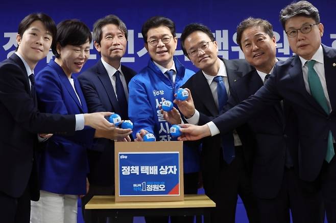 정원오의 ‘정책 택배’ - 더불어민주당 서울시장 후보인 정원오(왼쪽 네 번째) 전 성동구청장이 28일 서울 중구 선거대책위원회 사무실에서 열린 첫 공개 회의에서 상임선대위원장 등과 함께 자치구 정책 공약을 택배상자에 넣는 퍼포먼스를 하고 있다.  뉴스1