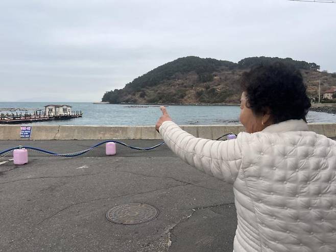 한씨가 안도 해녀들과 함께 작업하는 섬을 손가락으로 가리키고 있다.