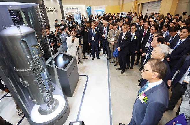 지난 4월 부산 해운대구 벡스코 제1전시장에서 개막한 '2026 부산국제원자력산업전'에서 관람객들이 혁신형 소형모듈원전(I-SMR) 모형을 살펴보고 있다./연합뉴스