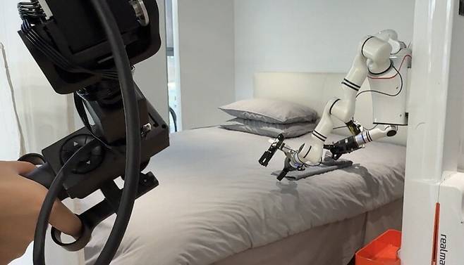 28일 베이징 스징산구 베이징인간형로봇데이터훈련센터에서 로봇이 침실로 꾸며진 환경에서 수건 개기를 연습하고 있다. 베이징/이정연 특파원