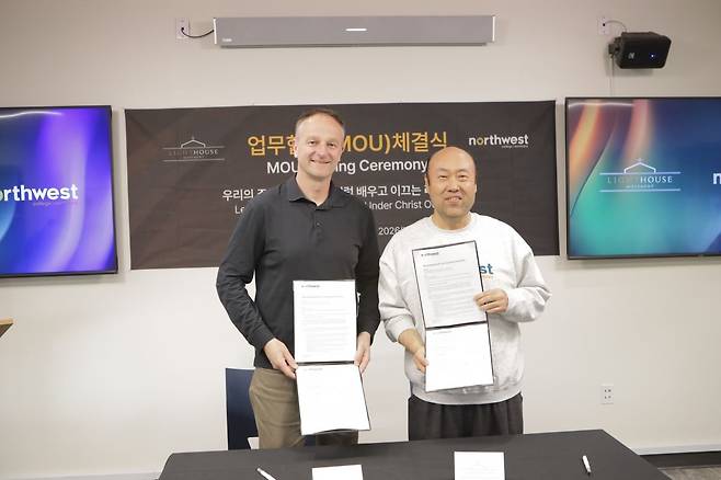 홍민기(오른쪽) 목사가 바튼 프리브 총장과 27일(현지시간) 캐나다 브리티시컬럼비아주 랭리의 NBS 캠퍼스에서 체결한 양해각서(MOU)를 들고 기념사진을 찍고 있다. 캐나다 크리스천신문 제공