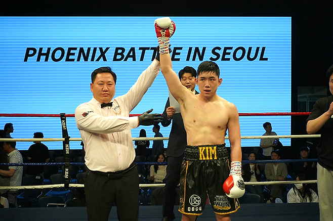 김용욱이 2026년 4월 서울특별시 강남구 섬유센터 이벤트홀 특설링에서 KBM 라이트헤비급 챔피언결정전 손경수 주심으로부터 승리 선언을 받고 있다. 슈퍼웰터급에 이은 두 체급 제패다. 사진=한국복싱커미션