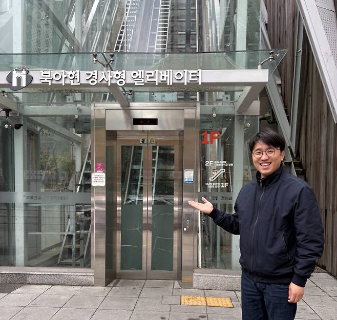 주이삭 개혁신당 최고위원(서울 서대문구 재선 의원)이 최근 서울 서대문구 북아현동에 위치한 경사형 엘리베이터 앞에서 선거 유세 이후 엘리베이터를 가리키는 모습. 이 엘리베이터는 기존에 가파른 계단을 400m 이상 돌아가야 했던 민원을 해결하기 위해 주 최고위원과 주민이 서울시 공모사업 예산 26억원을 따내 조성한 시설이다. / 사진=김인한 기자