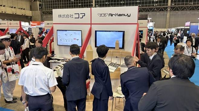 일본 최대 방위·안보 전시회 DSEI 재팬 2025에 마련된 에어 카무이 부스에서 관계자들이 골판지 무인항공기 ‘에어카무이 150’을 살펴보고 있다. 에어 카무이 홈페이지