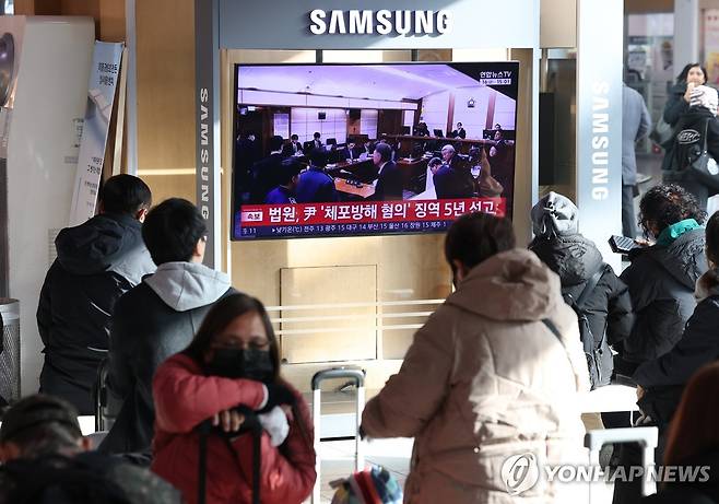 윤석열 전 대통령 '체포방해' 1심 선고 생중계 (서울=연합뉴스) 류영석 기자 = 16일 서울역 대합실에서 고위공직자범죄수사처(공수처) 체포 방해 등 혐의로 기소된 윤석열 전 대통령에 대한 1심 선고 공판이 TV를 통해 생중계되고 있다.
    이날 재판부는 윤 전 대통령에 징역 5년을 선고했다. 2026.1.16 ondol@yna.co.kr