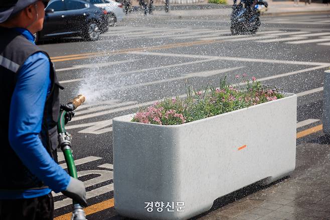 서울의 한낮기온이 24도까지 오른 30일 서울 광화문 광장에서 한 관리인이 화단에 물을 주고 있다. 2026.4.30 이준헌 기자
