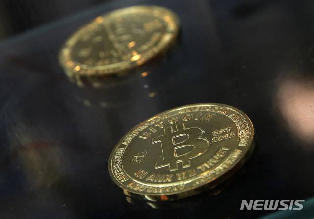 [홍콩=AP/뉴시스] 사진은 2017년 12월8일 홍콩의 비트코인 ATM 기계 옆에 비트코인 모형이 놓여있는 모습. 2026.04.30.
