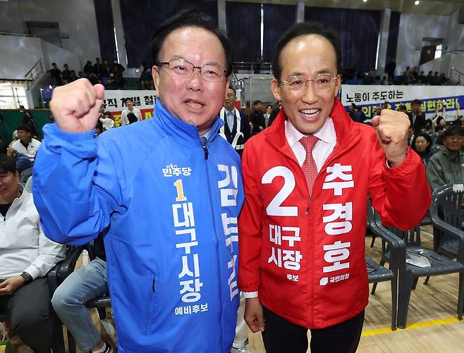 1일 대구 북구 대구복합스포츠타운 시민체육관에서 열린 한국노총 노동절 기념대회에서 더불어민주당 김부겸 대구시장 예비후보(왼쪽)와 국민의힘 추경호 대구시장 예비후보가 파이팅을 외치고 있다. /연합뉴스