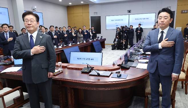 이재명 대통령이 30일 청와대에서 열린 수석보좌관회의에서 국기에 경례하고 있다. 오른쪽은 강훈식 비서실장. 연합뉴스