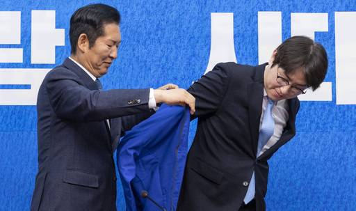 6·3 국회의원 재보선에 민주당 부산 북갑 후보로 출마한 하정우 전 청와대 AI수석(오른쪽)이 29일 국회에서 열린 민주당 인재 영입식에 참석해 정청래 당 대표의 도움으로 민주당의 상징인 파란색 점퍼를 입고 있다. 연합뉴스