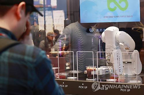 로봇이 만들어주는 커피 (서울=연합뉴스) 진연수 기자 = 21일 서울 강남구 코엑스에서 열린 2024 상반기 IFS 프랜차이즈 창업·산업 박람회에서 참관객이 로봇 커피 머신 시연을 보고 있다. 2024.3.21 jin90@yna.co.kr