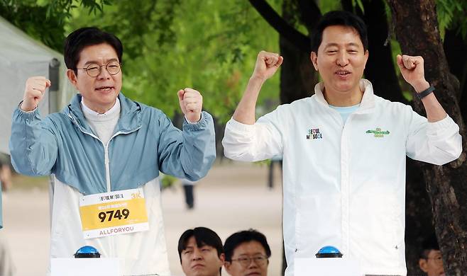 더불어민주당 서울시장 후보 정원오(왼쪽) 전 성동구청장과 국민의힘 후보 오세훈 서울시장이 2일 오전 서울 마포구 평화의공원 평화광장에서 열린 제26회 여성마라톤 대회에서 참가자들을 응원하고 있다. 뉴시스