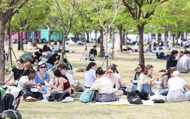 14일 서울 여의도 한강공원에서 외국인 관광객과 시민들이 나무 그늘아래에서 휴식을 취하고 있다. 사진=임형택 기자