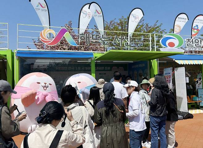 2026 태안국제원예치유박람회에 마련된 서산시 홍보 부스를 찾은 관람객들이 '가티와 오슈' 포토존에서 기념촬영을 하고 있다.(사진=서산시 제공)