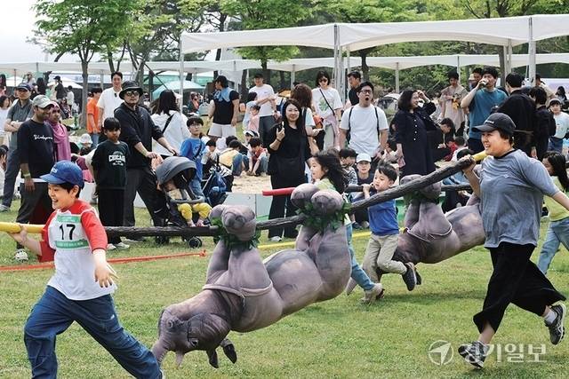 가족 참가자들이 ‘전곡리안 서바이벌: 전곡 쌍코뿔이 레이스’에 참여해 쌍코뿔이 모형을 운반하고 있다. 조주현기자