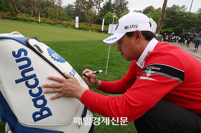 박상현(오른쪽)이 3일 경기 성남 남서울CC에서 GS칼텍스 매경오픈 행운상에 선수 애장품으로 내놓은 자신의 캐디백에 직접 사인하고 있다. 성남 이승환 기자
