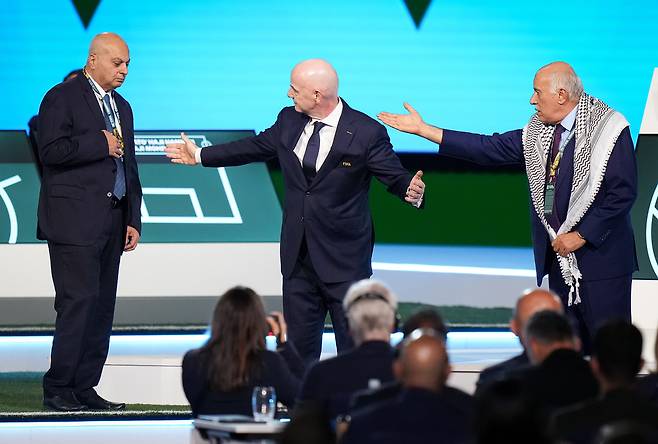 지브릴 라주브(오른쪽)가 지난  4월 30일 캐나다 밴쿠버에서 열린 제76차 FIFA 총회에서 잔니 인판티노(가운데)의 중에도 불구하고 이스라엘축구협회 부회장 바심 셰이크 술리만(왼쪽)과 함께 서는 것을 거부하고 있다. AP