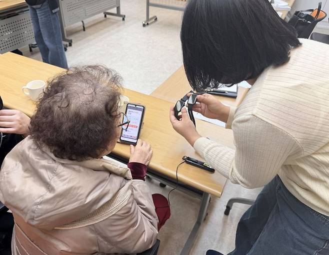 어르신에게 스마트워치 사용법을 설명하고 있다ⓒ광명시제공