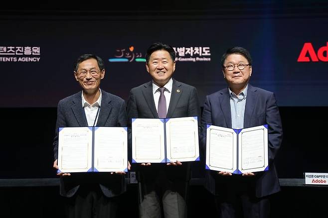 제주콘텐츠진흥원 강민부 원장(왼쪽부터), 오영훈 제주도지사, 이성순 어도비코리아 전무가 3월 17일 제주 비인공연장에서 ‘생성형 인공지능(AI) 기반 콘텐츠 산업 활성화’를 위한 업무협약을 체결한 뒤 협약서를 들어 보이고 있다. 이번 협약은 생성형 AI 콘텐츠 인재 양성과 지역 콘텐츠 기업의 AI 기술 활용 지원, 글로벌 네트워크 연계 협력을 담고 있다. /사진=제주특별자치도 제공