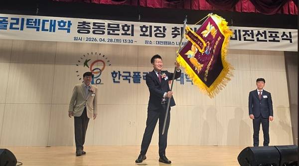 한국폴리텍대학 박근종(가운데) 초대 회장이 취임 기념 깃발을 흔들고 있다.