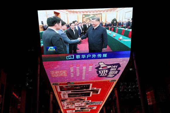 시진핑 중국 국가주석이 중국 주요 첨단기술 기업가들을 한자리에 불러모은 지난해 2월17일 인공지능 기업 딥시크 창업자 량원펑과 악수하는 모습이 베이징 시내 전광판에 비치고 있다. 베이징/로이터 연합뉴스