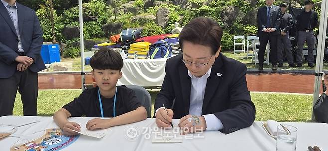 ▲ 이재명 대통령과 김혜경 여사는 5일 청와대에서 ‘2026년 제104회 어린이날 청와대 초청행사를 가진 가운데 이 대통령이 횡성초 3학년 박서후 군에게 메시지를 써주고 있다. 제공 횡성드림스타트