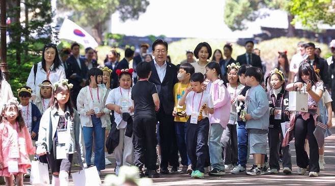 어린이들과 녹지원 향하는 이재명 대통령 부부 - 이재명 대통령과 김혜경 여사가 5일 어린이날 초청행사 참석자들과 함께 청와대 녹지원으로 향하고 있다.  연합뉴스