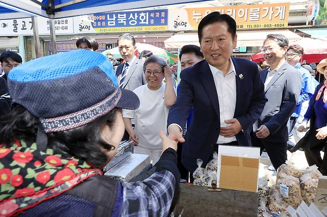 정청래 더불어민주당 대표가 5일 경기도 동두천시 중앙로 동두천큰시장을 찾아 상인과 인사를 나누고 있다. 2026.5.5/뉴스1