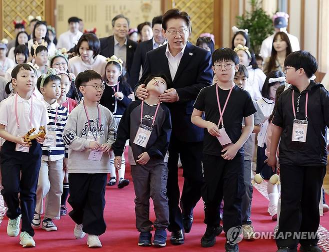 어린이들과 국무회의장 향하는 이재명 대통령 부부 (서울=연합뉴스) 김도훈 기자 = 이재명 대통령과 김혜경 여사가 5일 어린이날 초청행사 참석자들과 간담회를 마친 뒤 청와대 본관을 나서고 있다. 2026.5.5 [청와대통신사진기자단] superdoo82@yna.co.kr