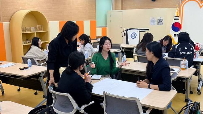 교사 연수에서 교사들이 사례와 경험을 공유하고 있다.