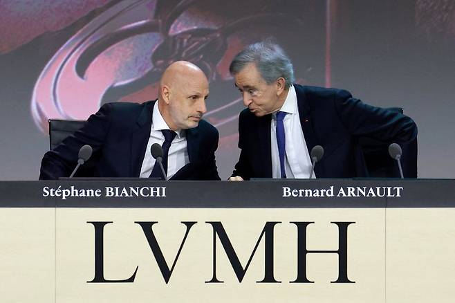 베르나르 아르노(오른쪽) 모에헤네시 루이뷔통(LVMH) 회장 겸 최고경영자(CEO)가 지난달 23일(현지시간) 프랑스 파리에서 열린 연례 주주총회에서 스테판 비앙키 LVMH 운영 총괄과 귀엣말을 나누고 있다. 로이터 연합
