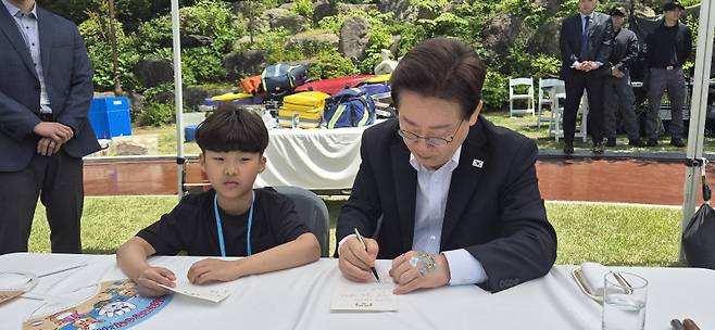 ▲ 이재명 대통령과 김혜경 여사는 5일 청와대에서 ‘2026년 제104회 어린이날 청와대 초청행사를 가진 가운데 이 대통령이 횡성초 3학년 박서후 군에게 메시지를 써주고 있다.  횡성드림스타트 제공