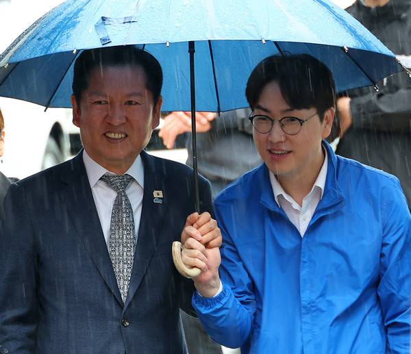 3일 오후 부산 북구 구포시장에서 더불어민주당 정청래 대표와 북갑 국회의원 보궐선거 출마를 공식화한 하정우 전 청와대 AI 미래기획수석이 우산을 쓰고 이동하고 있다. 2026.5.3 [사진=연합뉴스]