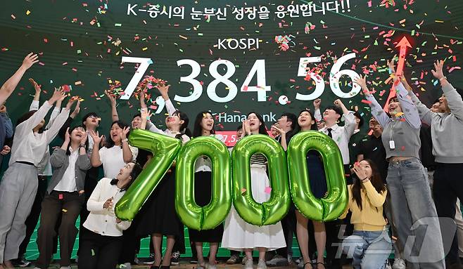 코스피가 종가 기준 사상 처음 7000선을 돌파한 6일 서울 중구 하나은행 딜링룸에서 직원들이 축하 세레머니를 하고 있다. (공동취재) 2026.5.6 ⓒ 뉴스1 박지혜 기자